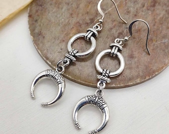 Può includere: Orecchini a forma di mezzaluna in argento con un ciondolo circolare e dettagli intricati. Gli orecchini hanno una chiusura a gancio.