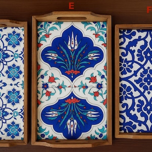 May include: Three rectangular wooden trays labeled D, E, and F. Tray D features a blue and white floral pattern. Tray E displays a blue, white, and red tulip motif. Tray F shows a blue and white intricate scrolling pattern. Each tray has handles.