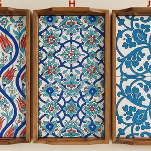 May include: Three rectangular wooden serving trays labeled G, H, and J. Each tray features a distinct ceramic tile inlay with intricate floral patterns in shades of blue, red, and white. The trays have raised edges and integrated handles.