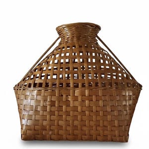 Könnte beinhalten: Ein gewebter Korb mit einer einzigartigen Form, der eine breite, rechteckige Basis hat, die sich nach oben zu einer schmaleren, abgerundeten Spitze verjüngt. Der Korb besteht aus hellbraunen, miteinander verwobenen Materialstreifen und hat zwei Griffe.