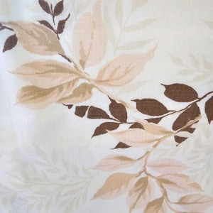 May include: White fabric with a brown and beige leaf pattern. The leaves are stylized and have a vintage look.