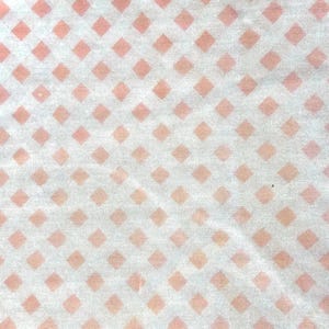 May include: White fabric with a repeating pattern of small pink diamond shapes.