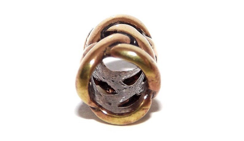 May include: A gold-toned metal bead with a braided design. The bead has a hollow center and is designed to be used as a hair tie or bracelet charm.