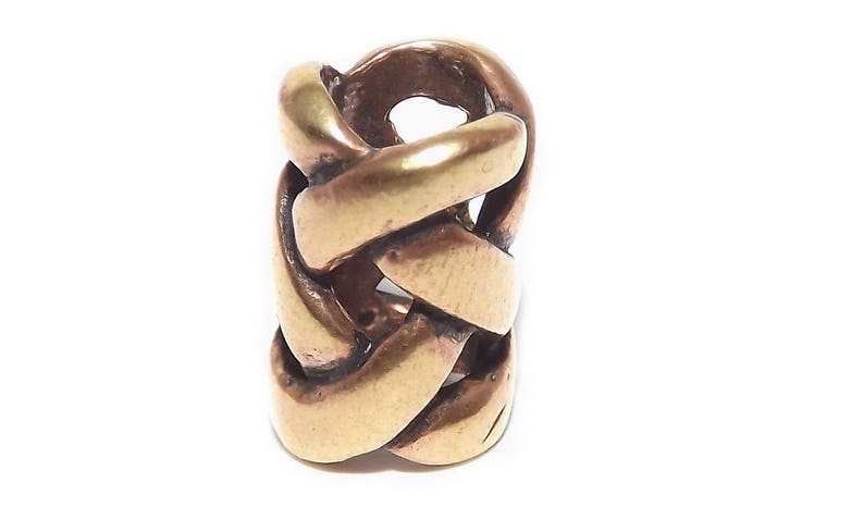 May include: A gold-toned metal braid hair cuff. The cuff is made of a series of interwoven bands that create a braided pattern.