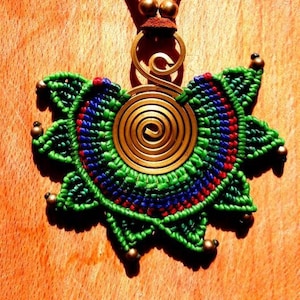 May include: A green and blue macrame necklace with a brass spiral pendant. The necklace is made with a brown leather cord.