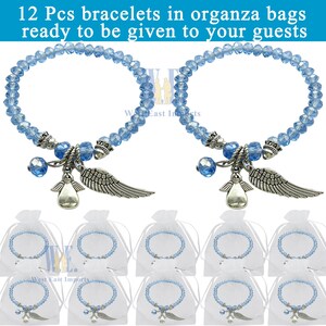 Puede incluir: Doce pulseras de cuentas de cristal azul claro con dijes plateados de &aacute;ngel y ala. Cada pulsera se acompa&ntilde;a de una bolsa de organza blanca. Se muestra el texto 12 Pcs bracelets in organza bags ready to be given to your guests.