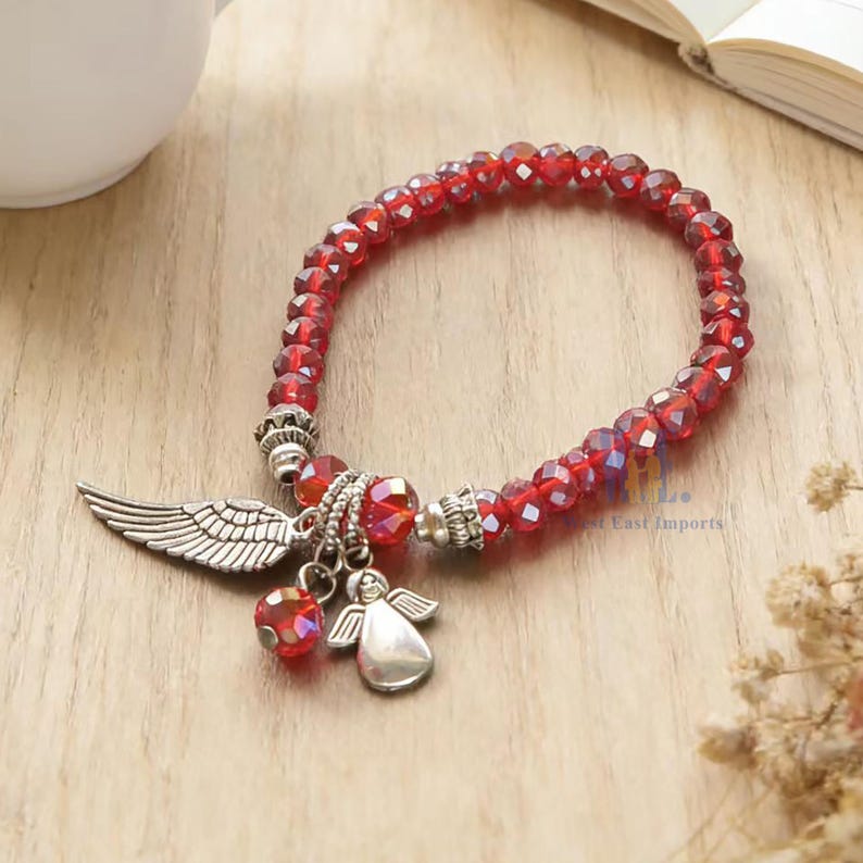 Puede incluir: Una pulsera el&aacute;stica compuesta por cuentas de cristal rojo facetado que presenta un dije de ala de metal plateado y un peque&ntilde;o dije de &aacute;ngel plateado. La pulsera incluye casquillos decorativos plateados y una cuenta de cristal roja colgante.