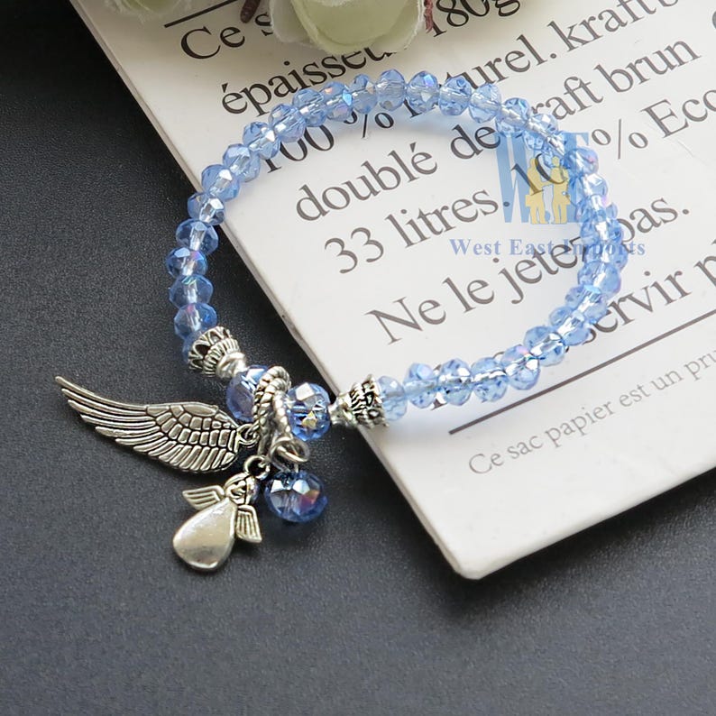 Pulsera con dije de alas de ángel y cuentas de cristal, recuerdo de bautizo, rosa, azul y transparente, con bolsitas de organza. imagen 3