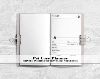 May include: An open notebook with white pages held by two silver binder clips. The right page features a Pet Profile form with fields for name, breed, DOB, gender, coat color, spay or neuter status, markings, tag number, microchip, allergies, and medications.