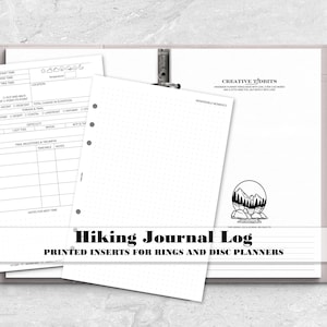 May include: A light gray ring planner containing white paper inserts for a hiking journal log. The pages feature printed fields for trail details, a dot grid layout, and a mountain graphic with the text Creative Tidbits and Hiking Journal Log.