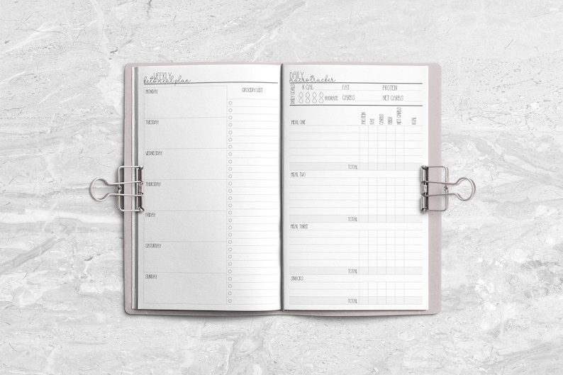 a planner is open on a marble surface
