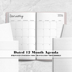 May include: A set of white paper notebook inserts featuring a dated 12-month agenda for 2026 with a January calendar view, alongside additional inserts with dot grid, graph, and lined page layouts for travelers notebooks.