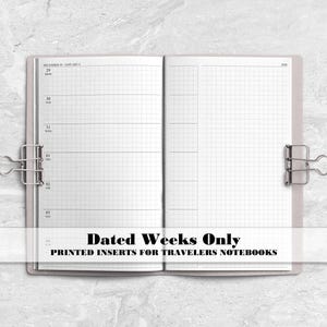May include: An open planner with white pages featuring a weekly layout on the left and a grid pattern on the right, held open by two silver metal binder clips. The text "Dated Weeks Only PRINTED INSERTS FOR TRAVELERS NOTEBOOKS" is centred.