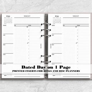 May include: A light pink six-ring binder planner open to two pages with black ink daily schedule layouts. The pages feature sections for breakfast, lunch, dinner, snacks, and hydration tracking. Text on the image reads Dated Day on 1 Page.