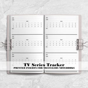 May include: An open notebook with white pages featuring a TV Series Tracker layout. The pages include sections for date, season, episode, and notes, with a calendar grid. Two silver metal binder clips hold the notebook open. Text reads TV Series Tracker.