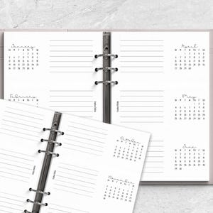 two spiral bound notebooks with a pen on top of them
