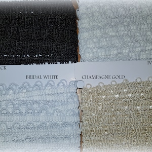 May include: Four samples of elastic trim in different colours: black, bridal white, champagne gold, and ivory. The trim is made of a woven material with a series of loops.