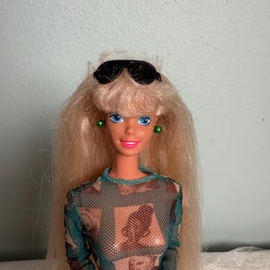 Barbie de Mattel de 1976, cabello rubio platino, ojos azules, rodillas dobladas, cuerpo giratorio.