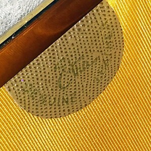May include: Close-up of a gold-colored label with the text "W.K. KING & CO. MELBOURNE" on a yellow fabric background.