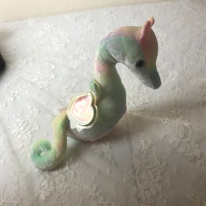 May include: A pastel blue, green, and pink seahorse beanie baby with a heart-shaped tag that says "Ty" and has a star on it.