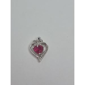 May include: A silver heart-shaped pendant with a vibrant red gemstone center. The pendant features a delicate design with small, sparkling accents along one side, creating a romantic and elegant look. A perfect gift for a loved one.
