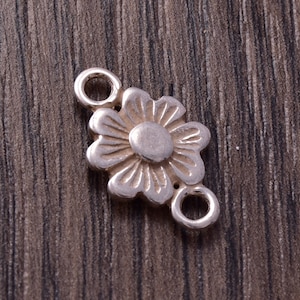 Può includere: Ciondolo a forma di fiore in argento con due anelli per attaccarlo a gioielli o altri oggetti artigianali.