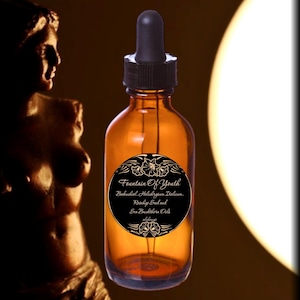 May include: An amber glass dropper bottle with a black cap and a circular black label. The label features the text Fountain Of Youth, Bakuchiol, Helichrysum Italicum, Rosehip Seed and Sea Buckthorn Oils, and Alchemy&oacute;, decorated with floral motifs.