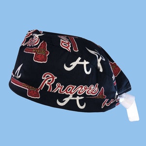 May include: A blue and white patterned surgical scrub hat with the Atlanta Braves logo and the words "Braves A" repeated on the fabric.