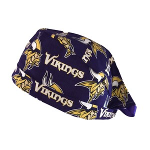 May include: Purple and gold patterned fabric scrub hat with the Minnesota Vikings logo repeated throughout the fabric.