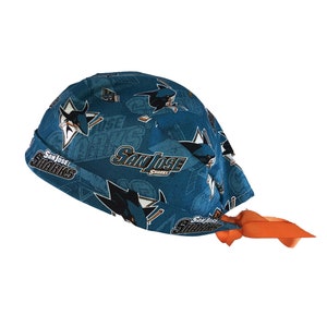 May include: A blue and orange patterned surgical cap with the San Jose Sharks logo. The cap has a tie on the side.