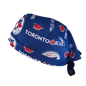 May include: Blue and white patterned fabric scrub hat with the Toronto Blue Jays logo and the words "Toronto Blue Jays".