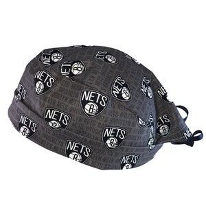 May include: Gray fabric face mask with a repeating pattern of the Brooklyn Nets logo and the words "Nets Brooklyn" in white.