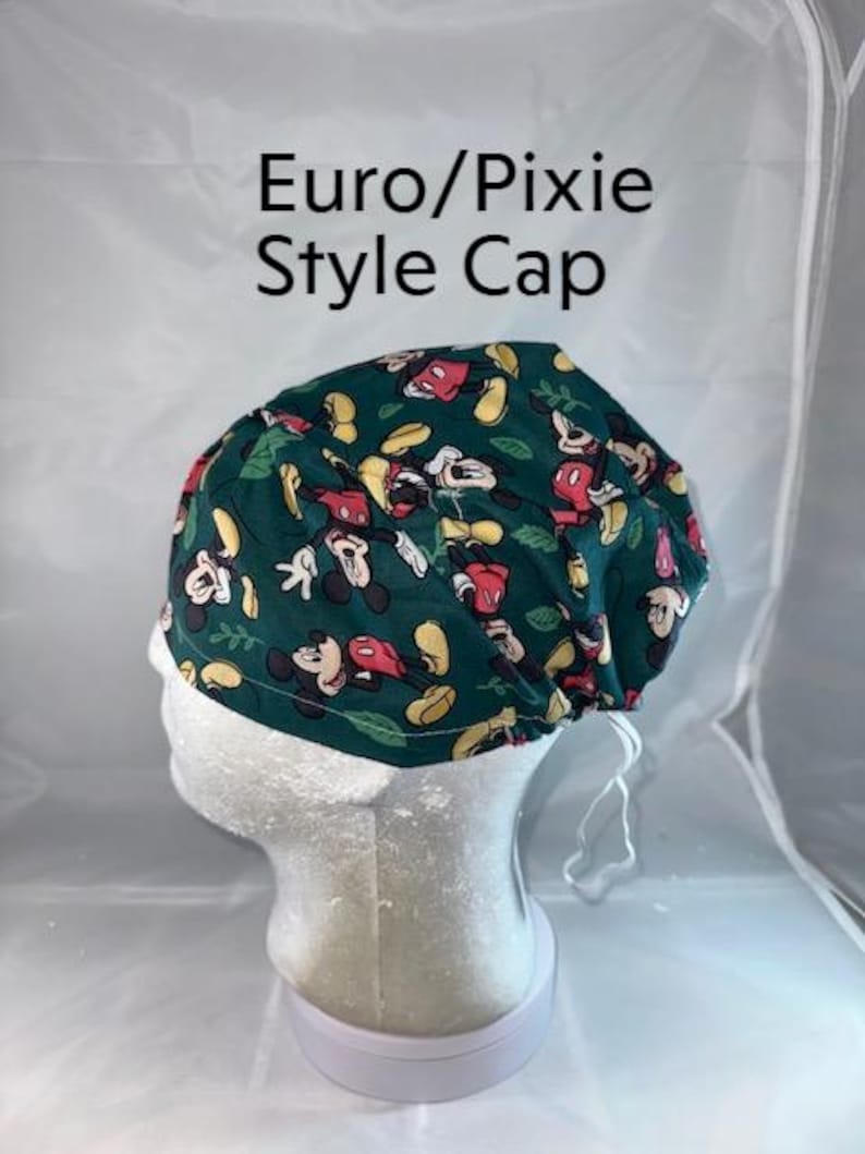 a white mannequin head with a green hat on top of it