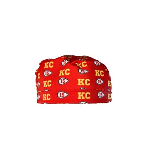 May include: Red beanie with a repeating pattern of yellow "KC" and "15" logos.