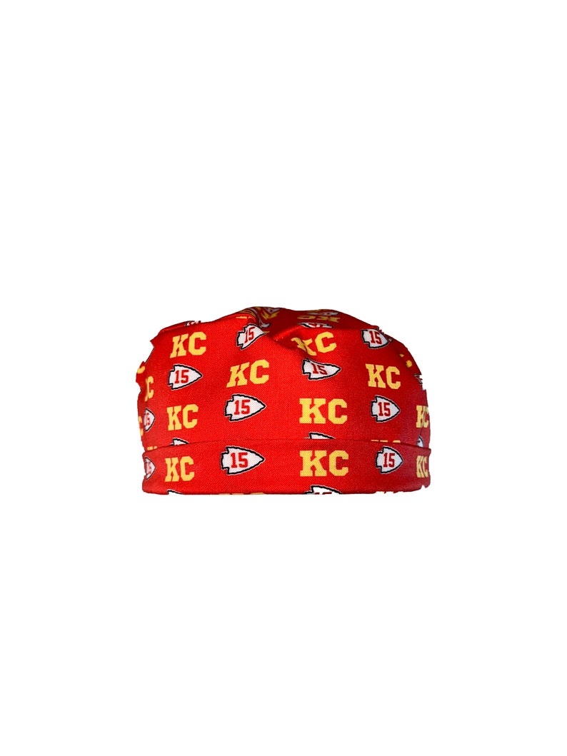 May include: Red beanie with a repeating pattern of yellow "KC" and "15" logos.