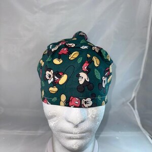 a close up of a baby wearing a mickey mouse hat