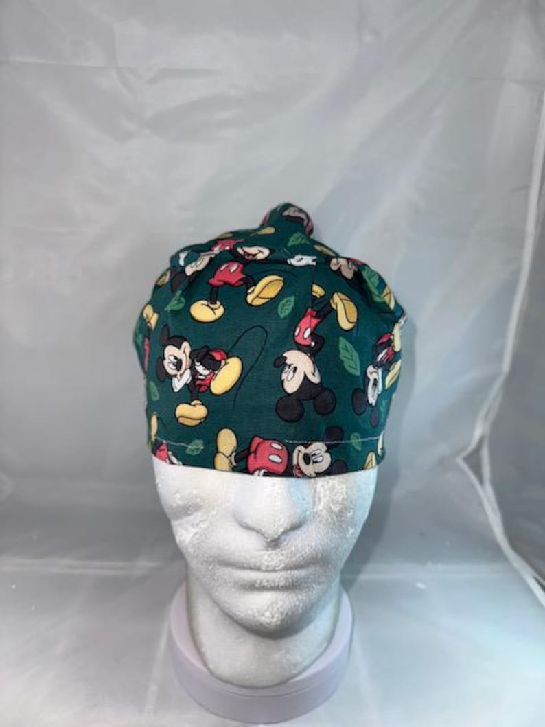 a close up of a baby wearing a mickey mouse hat