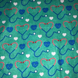 May include: Teal fabric with a repeating pattern of red and blue hearts, each containing a white EKG symbol.  The hearts are outlined in red and blue, and each heart is paired with a white stethoscope.