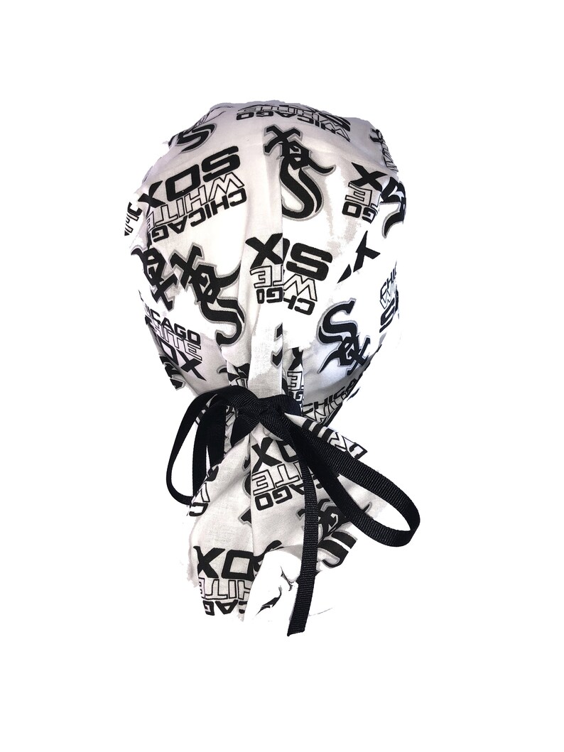 May include: White fabric surgical cap with black elastic ties. The cap is printed with a repeating pattern of the Chicago White Sox logo and the words "Chicago White Sox".