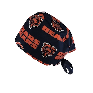 May include: A navy blue surgical scrub hat with a repeating pattern of orange bears and the word "Bears".