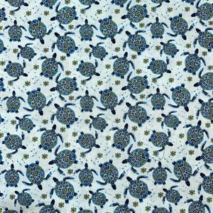 May include: A white fabric with a repeating pattern of blue and green sea turtles. The turtles are stylized and have a detailed design.