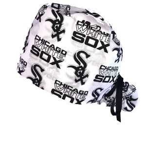 May include: White surgical scrub hat with a black and white print of the Chicago White Sox logo and text. The hat has a black drawstring.