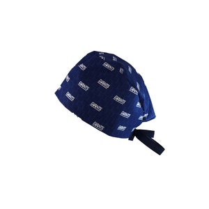 May include: A blue and white patterned surgical cap with a black tie. The cap has the word "Giants" repeated in a white pattern.