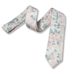 May include: A white necktie with a floral pattern featuring pink roses and grey leaves.