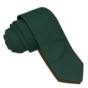 May include: A dark green necktie, folded and tied, ready to be worn.