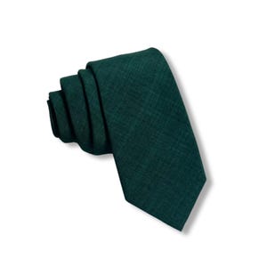Puede incluir: Una corbata de color verde oscuro hecha de una tela texturizada.