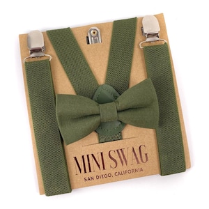 May include: A set of green suspenders and a matching bow tie. The suspenders have silver clips and the bow tie is made of a soft fabric. The set is packaged on a brown card with the text "MINI SWAG SAN DIEGO, CALIFORNIA".