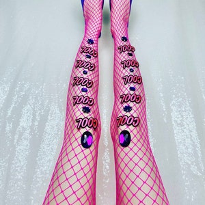 Könnte beinhalten: Ein Paar rosa Netzstrümpfe mit blauen spitzen Schuhen. Die Schuhe haben geschmückte Schnallen. Die Strümpfe haben mehrere rosa und blaue "COOL" Patches.