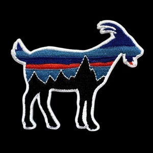 May include: Embroidered patch featuring a goat silhouette with a mountain range design. The goat is black with a white outline. The interior design features blue, red, and black horizontal stripes, and a mountain range.