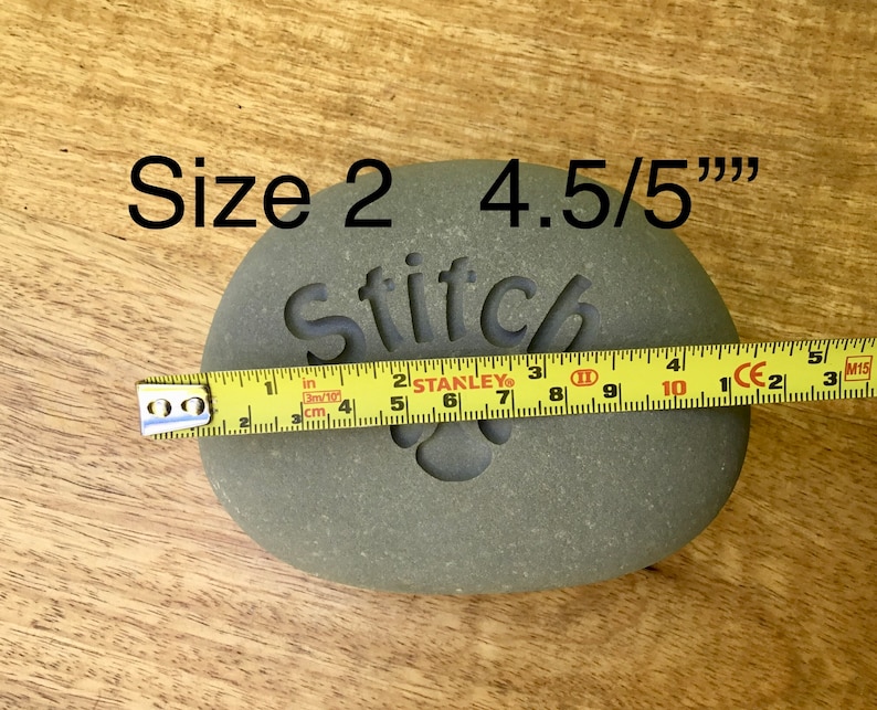 May include: A gray stone with the word "Stitch" engraved on it. The stone is 4.5 inches in diameter and is labeled "Size 2".